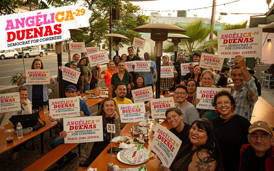Angélica Dueñas campaign event with supporters holding signs